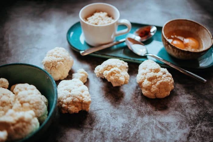 Suroviny na karfiolové placky – uvarený karfiol, cibuľa, mandľová múka, korenie, bylinky a olivový olej.